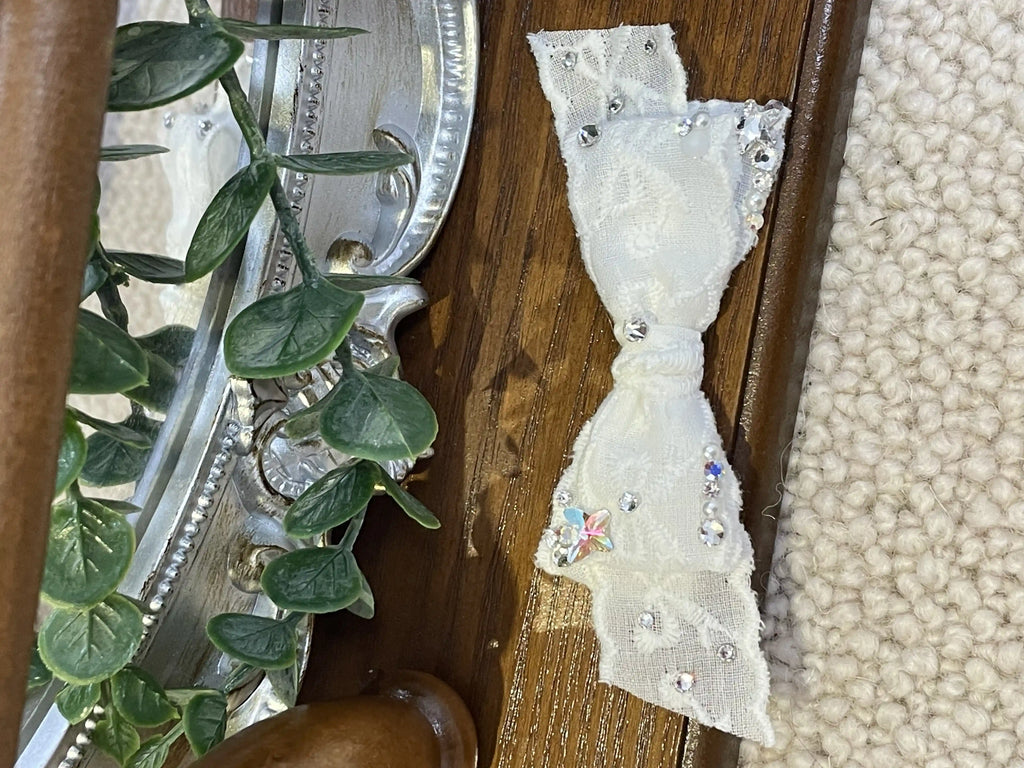 Close-up of Tinselpaw white lace dog bow with hand-set crystals.